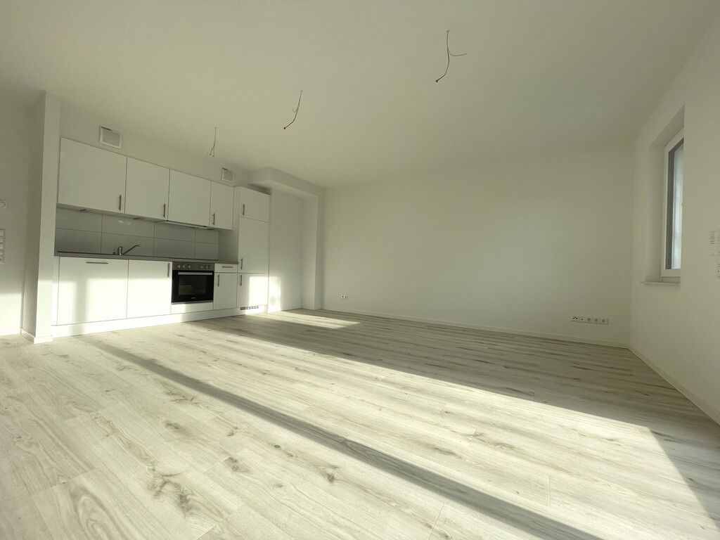 Wohnzimmer mit offener Einbauküche
